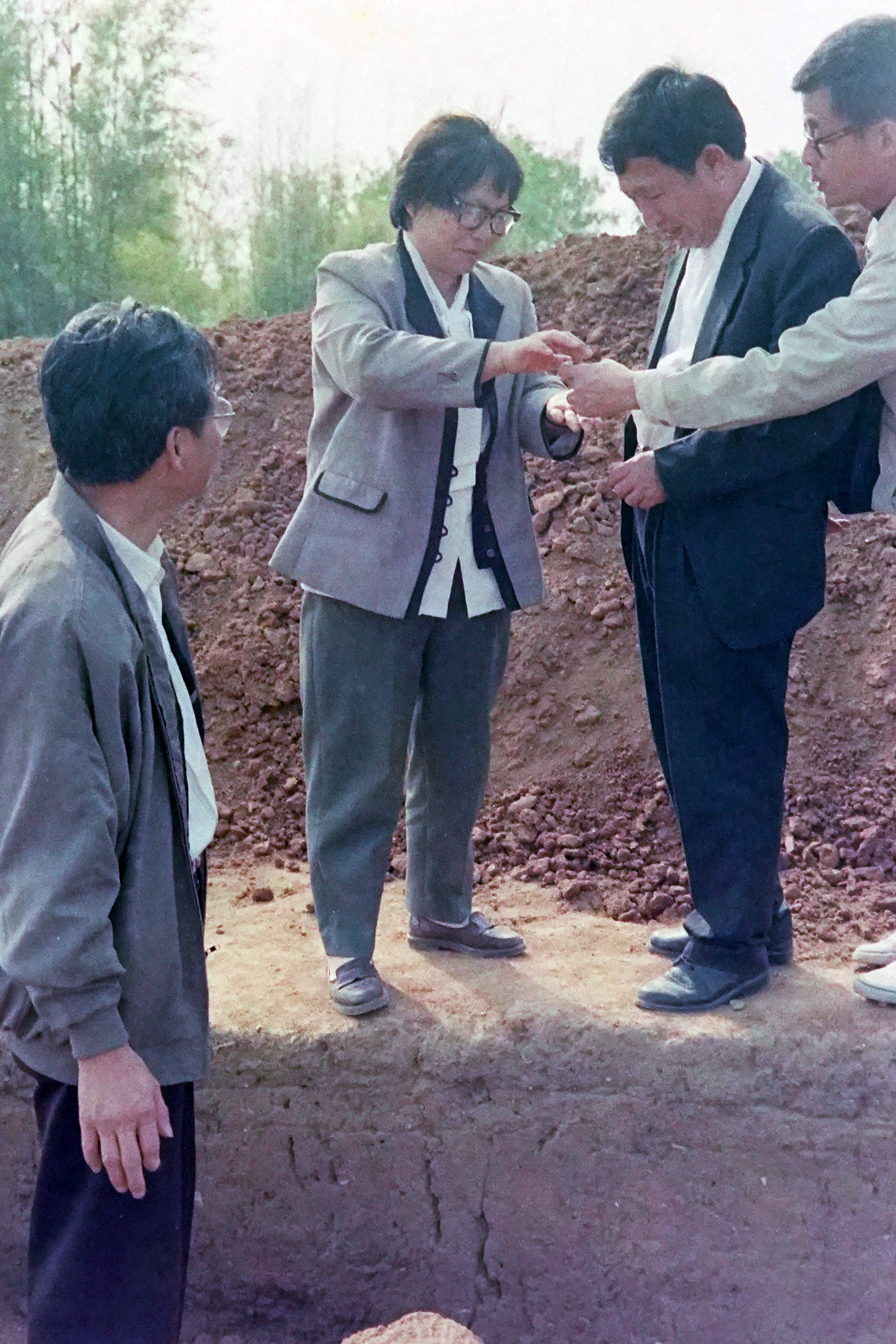 广东考古所副所长朱非素让政协主席冯文斌观看刚出土的石珠